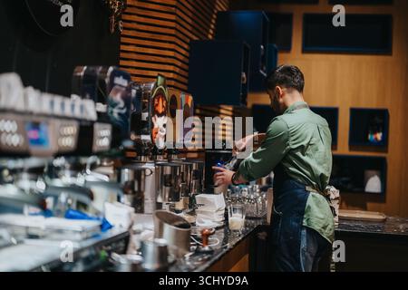 Barista che prepara il caffè in una caffetteria con attrezzatura per bevande Foto Stock