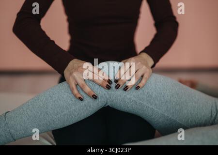 Fisioterapista che esegue la terapia sul ginocchio di un paziente in un ambiente clinico Foto Stock