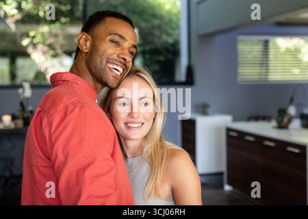 A casa, coppie diverse che abbracciano e condividono momenti di gioia insieme, sentendosi felici Foto Stock