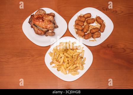 Pollo arrosto all'aglio con succo concentrato, con patatine fritte fatte in casa e spicchi di limone per esaltare i sapori. Foto Stock