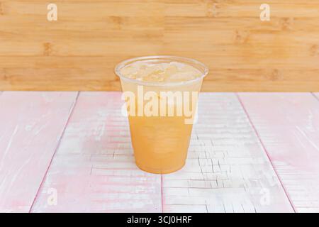 Sunshine Yellow Lemonade: Un bicchiere alto con cubetti di ghiaccio frizzante, fette di limone galleggianti e foglie di menta fresca che sapranno ogni sorso rinfrescante. Foto Stock