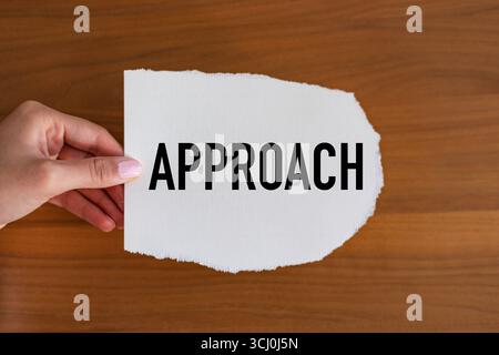 Approccio approccio. La mano della donna tiene un pezzo di carta con un biglietto, vintage. Metodo, strategia, procedura, piano, concetti. Note B1983 approccio Foto Stock