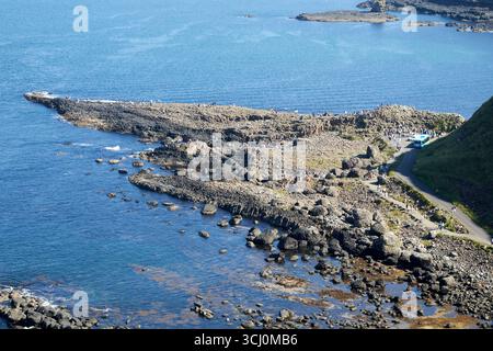 guardando in basso dal punto panoramico sul sentiero di scogliera superiore verso i turisti sulla strada rialzata gigante strada costiera della contea di antrim irlanda del nord regno unito Foto Stock