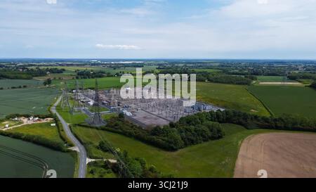 Vista aerea della sottostazione elettrica con piloni in un paesaggio rurale Foto Stock