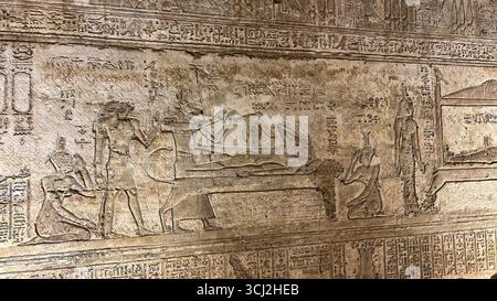 Dendera, Egitto - 10 febbraio 2025: Antico rilievo murale che mostra Osiride adagiato su un bier e Iside sotto forma di aquilone sopra di lui, che rappresenta il concept Foto Stock