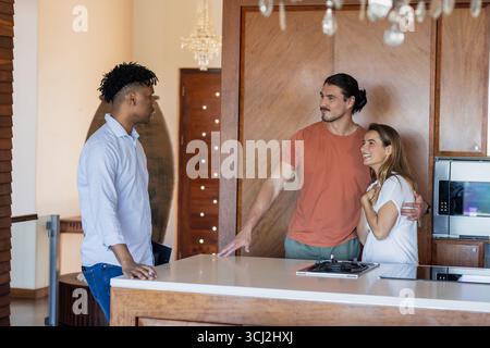 Amici che chiacchierano felicemente in una cucina moderna e si godevano una conversazione informale insieme. Amicizia, comunicazione, stile di vita, domestico, relax, gatheri Foto Stock