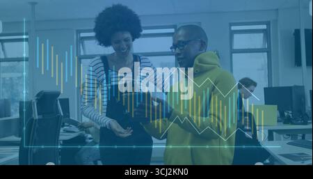 Revisione del referto stampato, dei colleghi con cappuccio giallo e delle tute appoggiate in ufficio, con grafici. Collaborazione, analisi dei dati, lavoro di squadra, professionisti Foto Stock