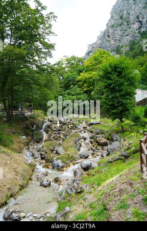 Cascata del fiume Giovanni a Limone sul Garda con vista sulle montagne Foto Stock