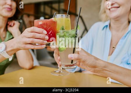Gruppo di donne di mezza età che brincono cocktail colorati insieme Foto Stock