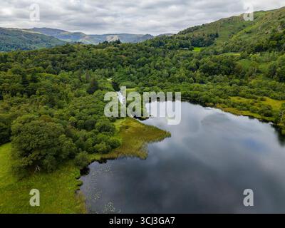 Vista aerea dall'alto dell'acqua Rydal, circondata da una lussureggiante foresta verdeggiante nel Lake District Foto Stock
