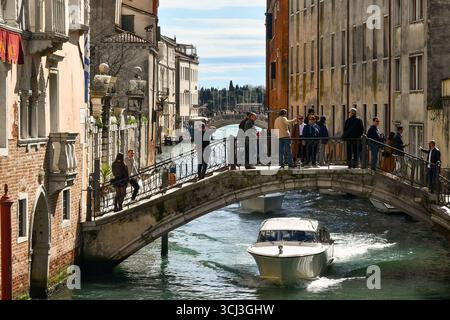Turisti sul ponte dei Greci sul Rio dei Greci, nel sestiere di Castello, in primavera, Venezia, Veneto, Italia Foto Stock