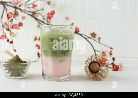 Tè verde Sakura freddo, latte di ghiaccio Matcha su tavolo bianco Foto Stock
