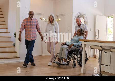 Camminare insieme, amici anziani che conversano a casa, sorridono e parlano Foto Stock