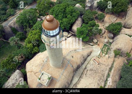 Vista aerea di un faro maestoso arroccato su massicce rocce di granito, circondato da vegetazione lussureggiante e sentieri, Mahabalipuram, Tamil Nadu, India. Foto Stock