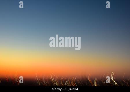 Cielo vibrante con magiche sfumature di colore e percorsi artistici di luce sotto. Sfondo naturale astratto, sognante e suggestivo, perfetto per i progetti. Foto Stock
