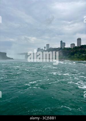 Le acque si infrangono sotto le cascate del Niagara con vista sui grattacieli in Canada Foto Stock