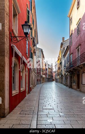 Strada di ciottoli vuota nella colorata città europea. Strada lastricata curva fiancheggiata da colorati edifici storici in un'affascinante cittadina europea Foto Stock