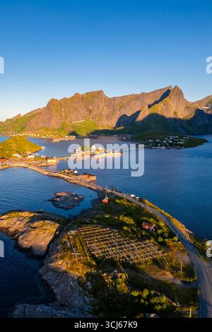 Vista aerea dell'isola di Sakrisøya e della baia di Reine verso Reinebringen in estate all'alba durante il sole di mezzanotte. Isole Lofoten, Norvegia. Foto Stock