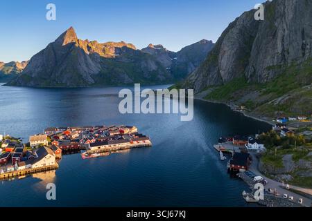 Vista aerea del monte Olstinden e dell'isola di Sakrisøya nella baia di Reine durante l'alba al sole di mezzanotte in estate. Isole Lofoten, Norvegia. Foto Stock
