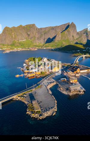 Vista aerea dell'isola di Sakrisøya e della baia di Reine verso Reinebringen in estate all'alba durante il sole di mezzanotte. Isole Lofoten, Norvegia. Foto Stock