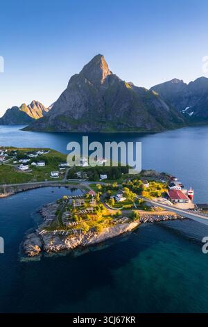 Vista aerea del monte Olstinden e dell'isola di Sakrisøya nella baia di Reine durante l'alba al sole di mezzanotte in estate. Isole Lofoten, Norvegia. Foto Stock