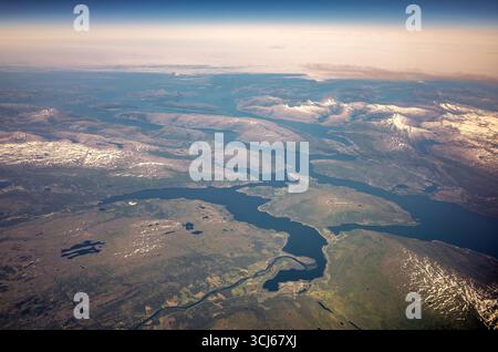 Fiordo di Lyngen e Alpi di Lyngen da Air Troms og Finnmark Norvegia // FIORDO DI LYNGEN, Norvegia: Una vista aerea cattura il suggestivo paesaggio dei fiordi di Troms og Finnmark, Norvegia settentrionale, guardando a nord verso il Mare di Norvegia. Il fiordo di Lyngen, una lunga insenatura, è centrale rispetto all'immagine, fiancheggiato dalle Alpi Lyngen innevate sul lato orientale, con picchi che si innalzano per oltre 1.500 metri (4.921 piedi). A ovest, Ullsfjord scorre nell'entroterra, con Balsfjord e Sørfjorden più a ovest, collegandosi verso Tromsø. Kåfjord, un fiordo di diramazione sul lato orientale, è visibile, così come il fiordo di Kvænangen nell'apertura sullo sfondo Foto Stock