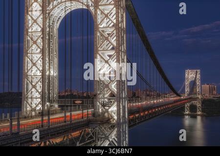 GW Bridge The Illuminated Gateway - le torri del George Washington Bridge brillano contro il blu profondo del cielo notturno. Foto Stock