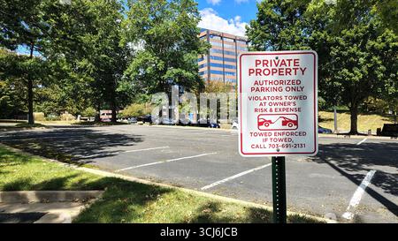 Chantilly, va, USA - 28 ottobre 2025: Un cartello che informa che questo parcheggio è riservato solo a persone autorizzate, con un edificio residenziale Foto Stock