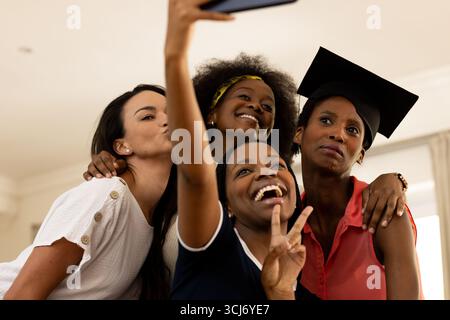 Festeggiamo la laurea, le diverse amiche si fanno selfie e sorridono con gioia Foto Stock