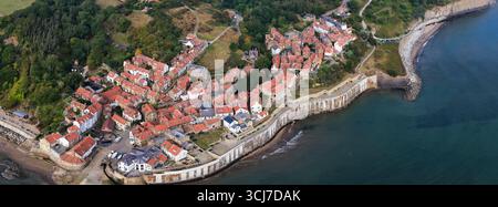 Vista panoramica aerea della Robin Hood's Bay sulla costa dello Yorkshire, Inghilterra, che mostra lo storico villaggio di pescatori con case dal tetto rosso e una strada tortuosa Foto Stock