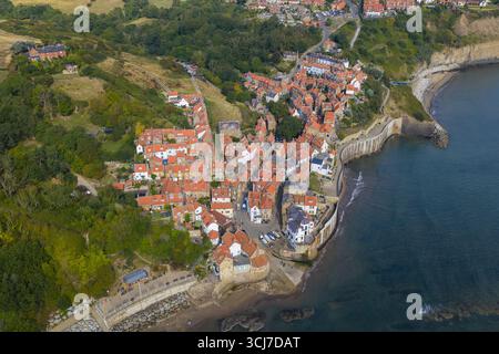 Vista panoramica aerea della Robin Hood's Bay sulla costa dello Yorkshire, Inghilterra, che mostra lo storico villaggio di pescatori con case dal tetto rosso e una strada tortuosa Foto Stock