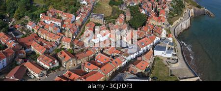 Vista panoramica aerea della Robin Hood's Bay sulla costa dello Yorkshire, Inghilterra, che mostra lo storico villaggio di pescatori con case dal tetto rosso e una strada tortuosa Foto Stock