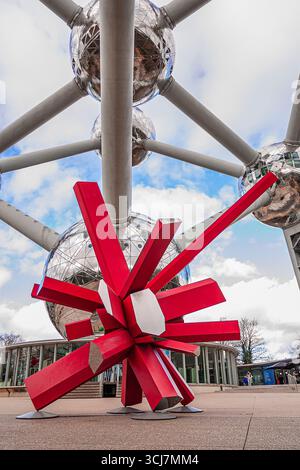 Un'opera d'arte rossa ai piedi dell'iconico Atomium di Bruxelles Foto Stock