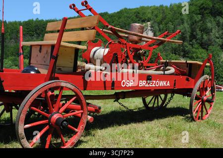 Pompa antincendio storica trainata da cavalli dell'OSP Brzeżówka durante le competizioni antincendio a Rudawka Rymanowska, Podkarpackie, Polonia Foto Stock