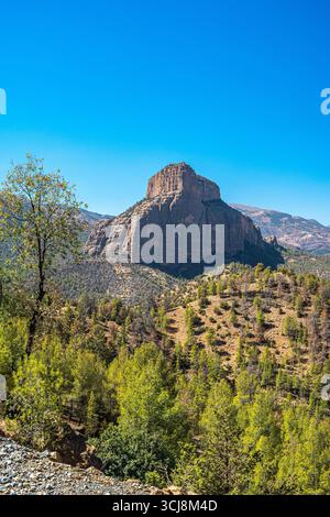 Montagne dell'Atlante paesaggio del Marocco con grande mesa rocciosa circondata da colline boscose sotto un cielo azzurro cristallino che crea una vista panoramica del deserto Foto Stock