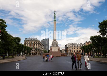 Riga, Lettonia - 24 giugno 2015 - monumento della libertà a riga con una folla diversificata in giornata nuvolosa. Foto Stock