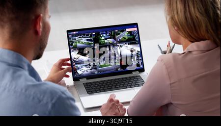Donna che guarda le riprese CCTV su un notebook per garantire la sicurezza della famiglia. Uomo che monitora il sistema di videosorveglianza da un laptop Foto Stock