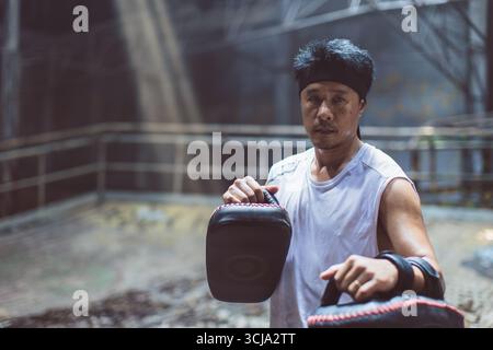Allenatore di boxe thailandese, istruttore di caccia thailandese Portrait muay, pugile giovanotto, kickboxing maschile, arti marziali asiatiche Foto Stock