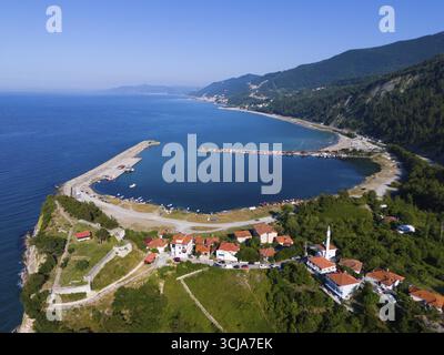 Veduta aerea di una città costiera con tetti rossi circondata da verdi colline e mare blu calmo, veduta aerea, Ginolu Bay, Ginolu, provincia di Kastamonu, Turchia Foto Stock