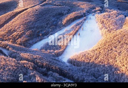 Neve sulle piste da sci della stazione sciistica in una giornata invernale di sole Foto Stock