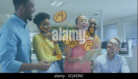 Revisione del design della rete su tablet cinque professionisti che indossano abiti da lavoro in un ufficio open space Foto Stock
