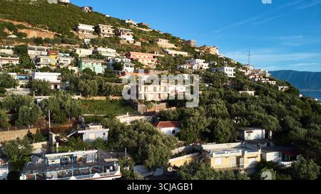 Piccola cittadina sulla cima di una collina con edifici, alberi e pittoresco paesaggio naturale Foto Stock