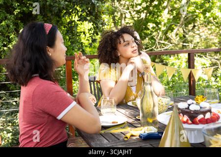 Amici che si divertono a festeggiare all'aperto con cibo e bevande nelle giornate di sole Foto Stock