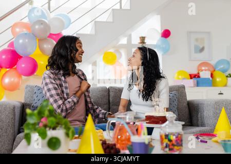 Festeggiamo il compleanno, madre e figlia afroamericana si divertono a casa Foto Stock