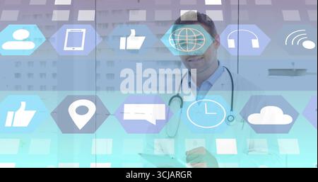 Medico in camice da laboratorio e stetoscopio navigando icone fluttuanti in ufficio medico, tenendo tablet Foto Stock