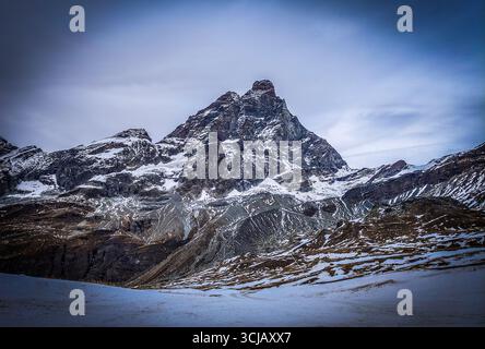Una maestosa vista invernale dell'iconico Cervino, una delle montagne più famose delle Alpi italiane. La vetta innevata si eleva dr Foto Stock