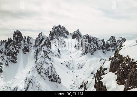 Vista mozzafiato delle cime innevate delle Dolomiti, Italia, che mostrano uno splendido paesaggio invernale sotto un cielo nuvoloso. Le maestose montagne offrono un Foto Stock