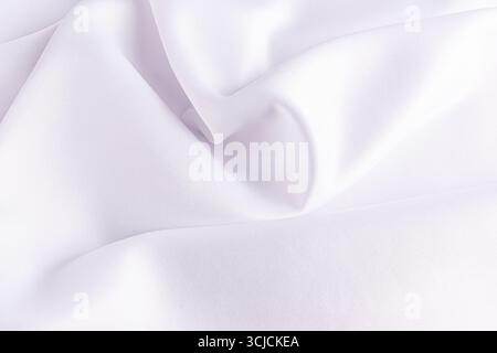 Elegante tessuto satinato bianco con morbide pieghe per una texture ricca e lussuosa. Perfetto come sfondo per matrimoni a tema, offre un Foto Stock