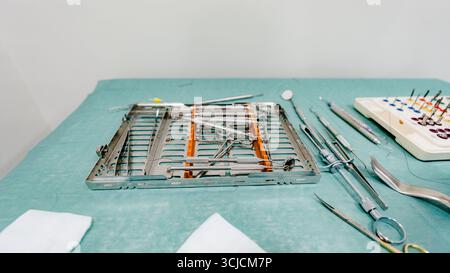 Vari strumenti di implantologia dentale disposti ordinatamente su un vassoio sterile nello studio dentistico. Attrezzature essenziali come trapani e bisturi per una precisione di o. Foto Stock