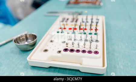 Un primo piano dettagliato degli strumenti di implantologia in un moderno studio odontoiatrico. L'immagine mostra gli strumenti di precisione utilizzati in odontoiatria per la chirurgia implantare, Foto Stock